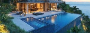 Villa moderne avec piscine à débordement et jardin luxuriant au crépuscule.